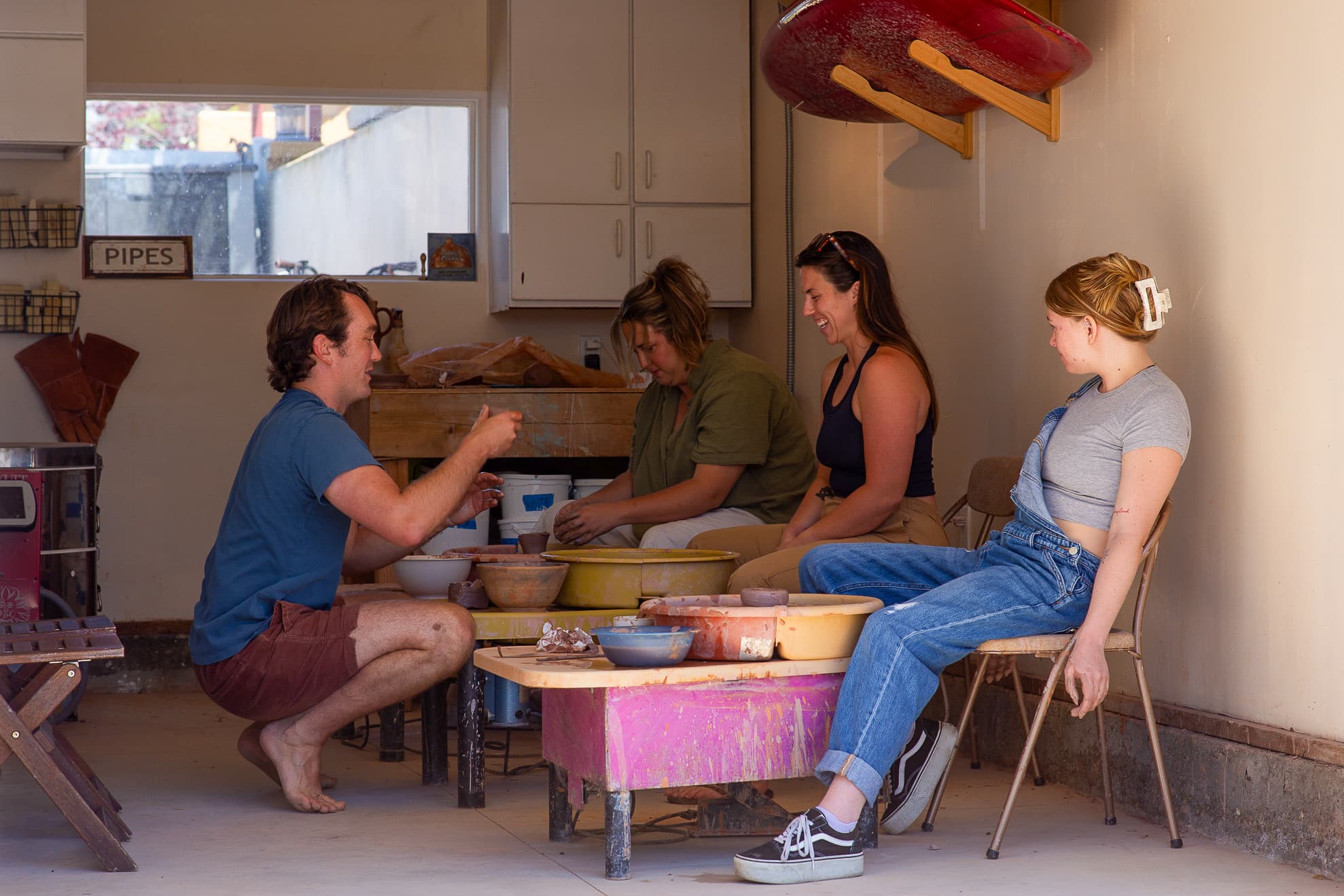 Group pottery class in the studio with surfboards on wall