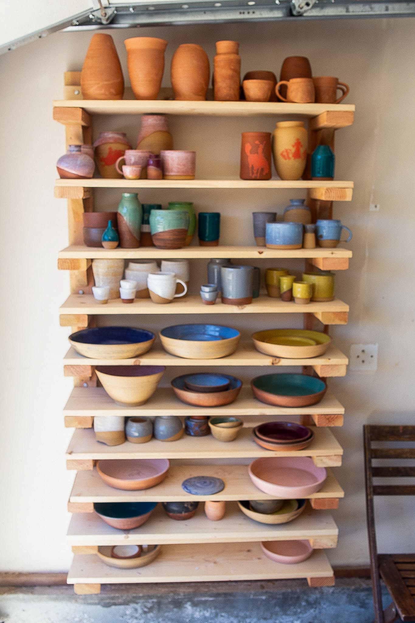 Pottery collection on wooden shelves